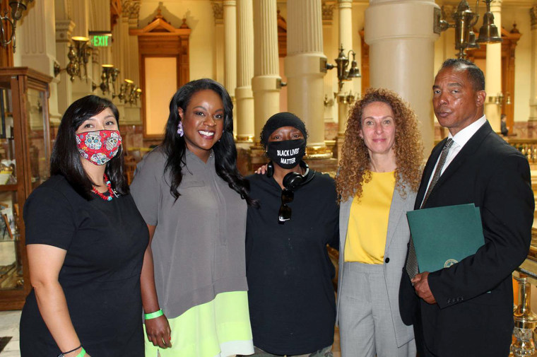 Rep. Serena Gonzales-Gutierrez, Rep. Leslie Herod, Sheneen McClain, mother of Elijah McClain, Mari Newman, and Rev. Promise Lee celebrate at the State House of Representatives after the Senate Bill 20-217, a police reform bill, passed with bipartisan support on June 12, 2020. Rep. Leslie Herod, Mari Newman and Rev. Promise Lee removed their masks for this photo.