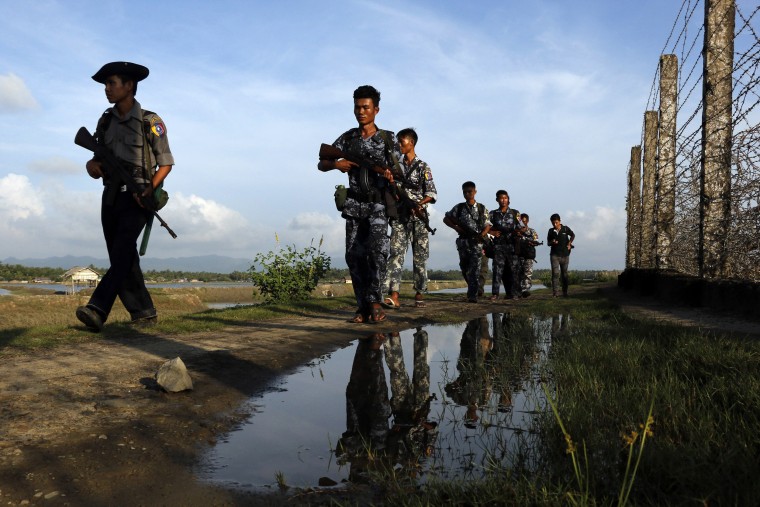 Myanmar police officers patrol along the border fence between Myanmar and Bangladesh in October 2016.