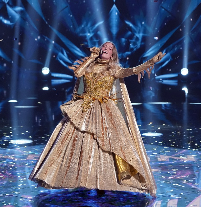 The unmasked singer! Rimes sings without her mask.