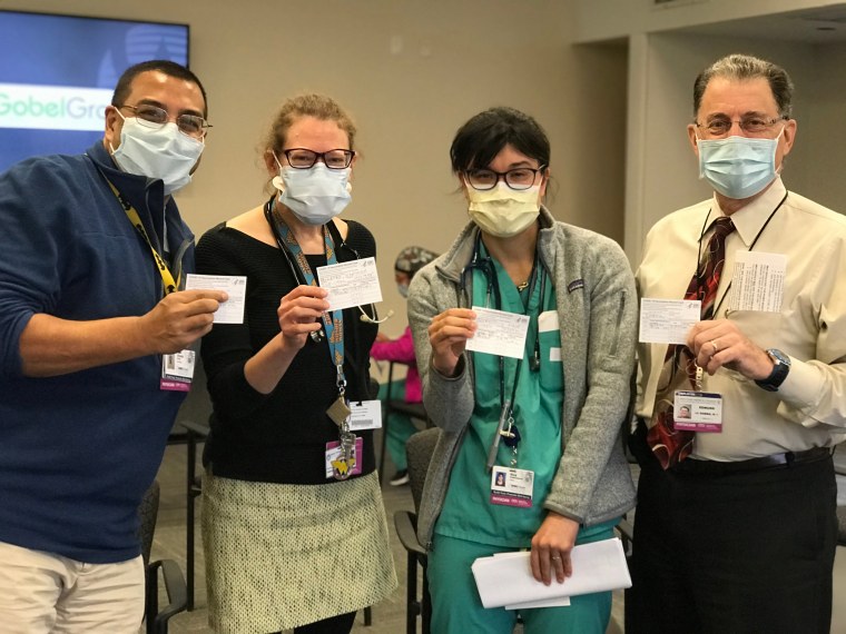 Doctors pose proudly together after getting vaccinated.