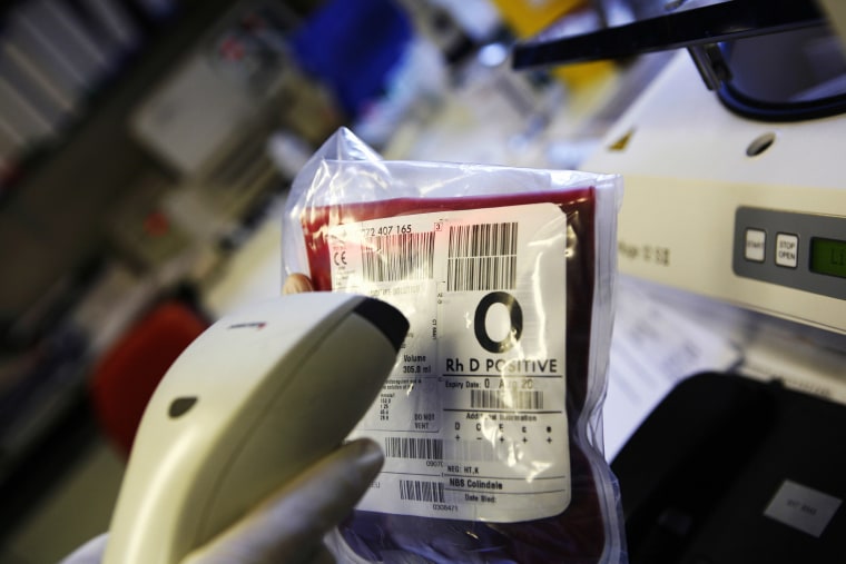 Image: A technician scans bar codes on bags of donated blood, United Kingdom.