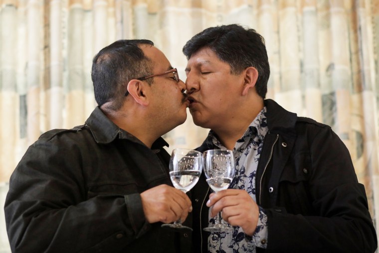 Image: Members of LGBT movement, kiss after a news conference where the first same-sex civil union recognised by the Bolivian Civil Registry in La Paz
