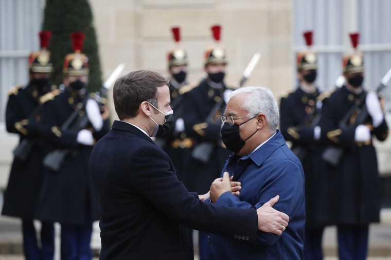 Image: French President Emmanuel Macron, left, welcomes Portuguese Prime Minister Antonio Costa in the courtyard of the Elysee Palace, before a working lunch