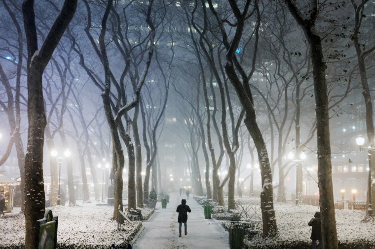 Image: People walk through Manhattan in a snow storm on Dec. 16, 2020 in New York City