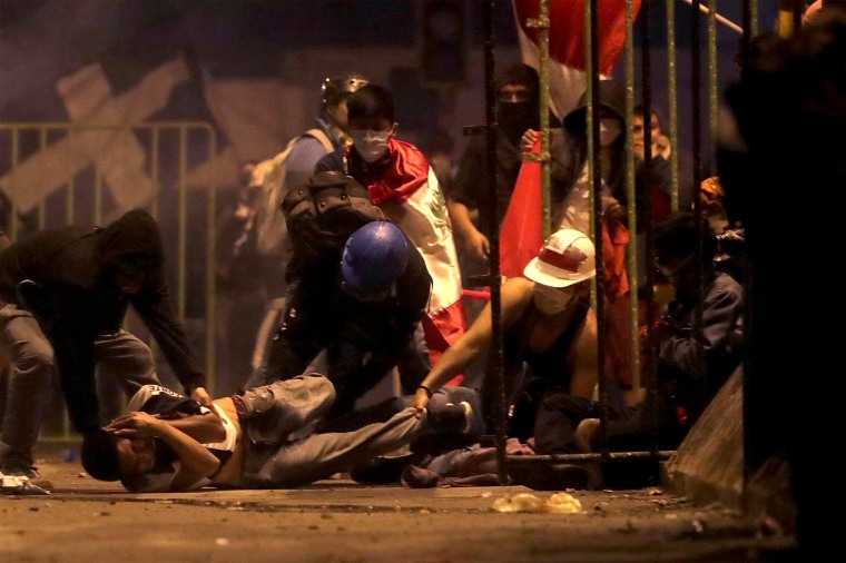 Image: FILE PHOTO: A demonstrator is injured on the ground as he is help by other demontrators during a clash with police during a protest against the decision of Congress to remove former President Martin Vizcarra, in Lima