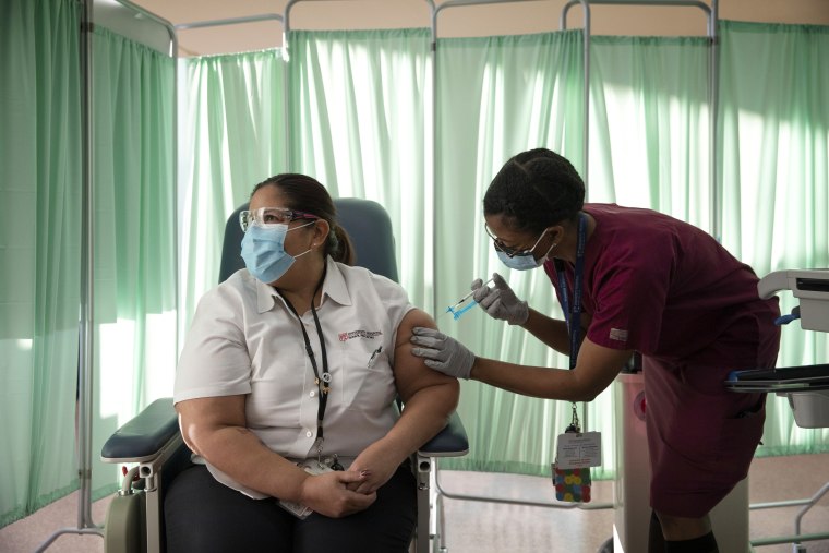 Image: Sady Ferguson administers a Covid vaccine to medical office assistant Yvelisse Covington at University Hospital in Newark, N.J., on Dec. 15, 2020.