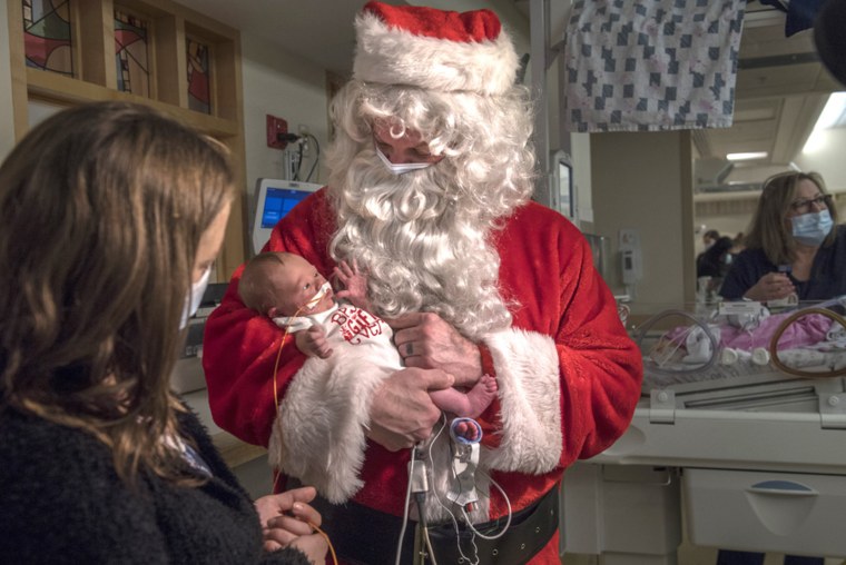 Santa posed with a newborn. 