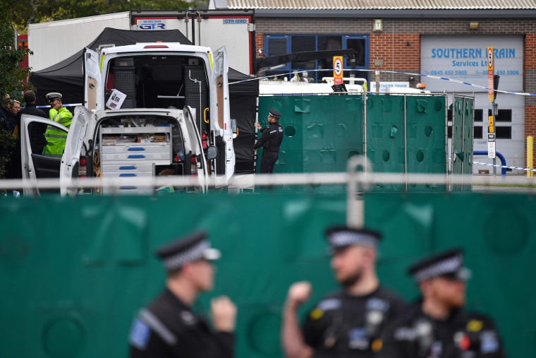 Image: British Police officers work near a lorry, believed to have originated from Bulgaria, and found to be containing 39 dead bodies, inside a police cordon at Waterglade Industrial Park in Grays, east of London
