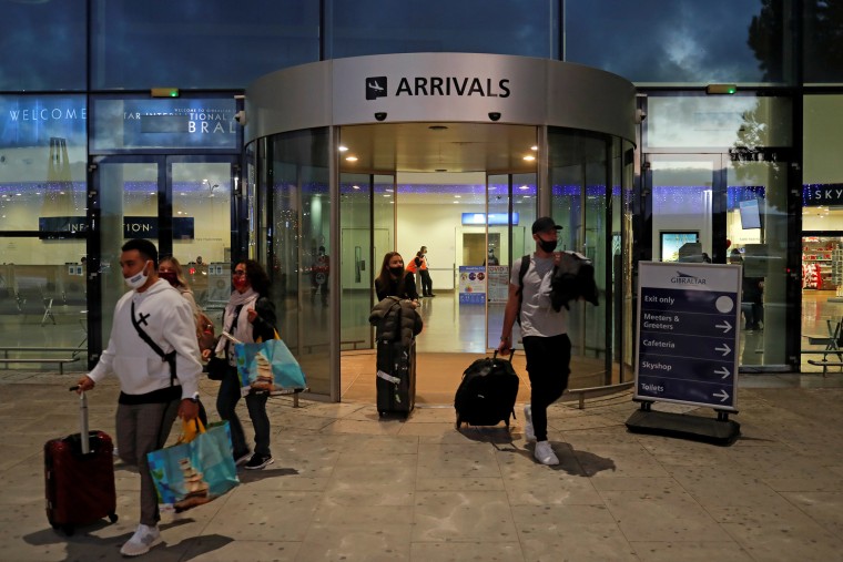 Image: Passengers walk out of the Gibraltar International Airport after the Spanish government announced it will ban all travelers from Britain, except Spanish nationals and residents