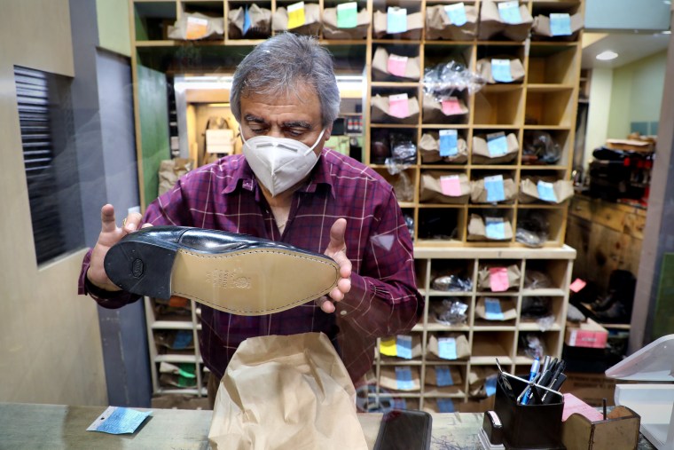 Eddie's Shoes owner Hugo Adraix reviews the stitching of a re-soled shoe in his shop in Rockefeller Center on Dec. 22, 2020.