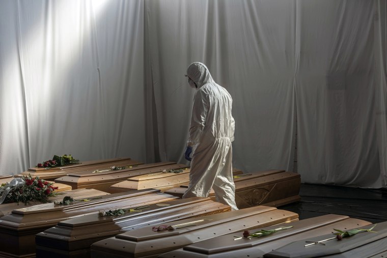 Image: A Civil Protection member is seen in the hangar where 18 coffins of victims of COVID-19 wait to be transported to Florence by the Italian Army to be cremated