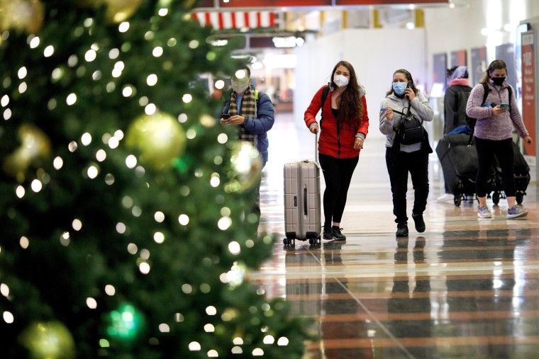 Holiday travelers wearing face masks are seen at Ronald Reagan Washington National Airport in Arlington, Va., on Dec. 23, 2020.