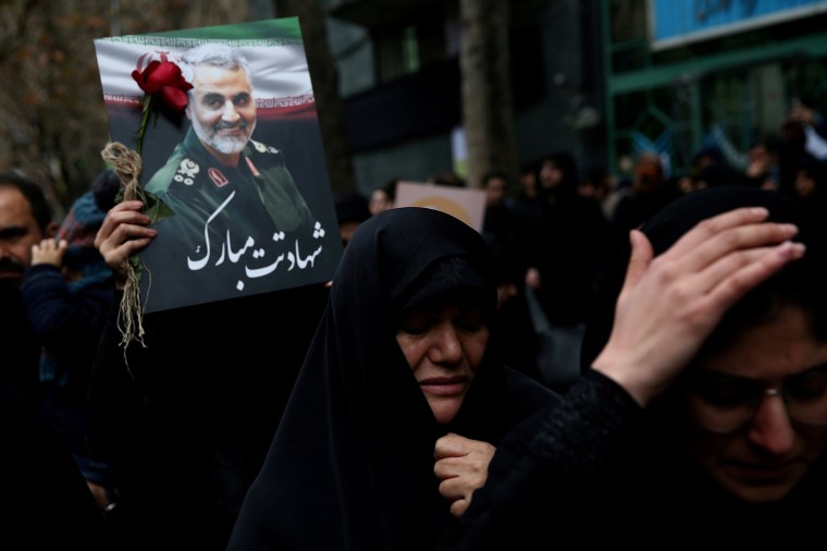Mourners hold a photo of Gen. Qassem Soleimani in Tehran, Iran,