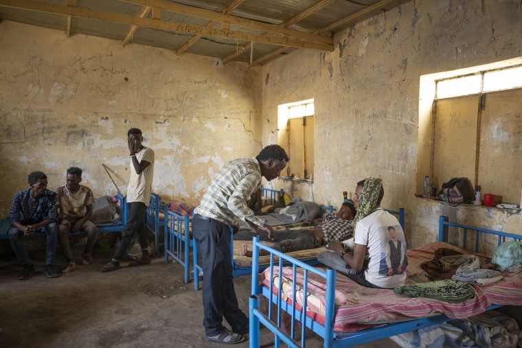 Image: Surgeon and doctor-turned-refugee, Tewodros Tefera, checks the wounds of Abrahaley Minasbo a 22-year-old trained dancer and Tigrayan survivor from Mai-Kadra, Ethiopia, at the Hamdeyat Transition Center near the Sudan-Ethiopia border, eastern Sudan