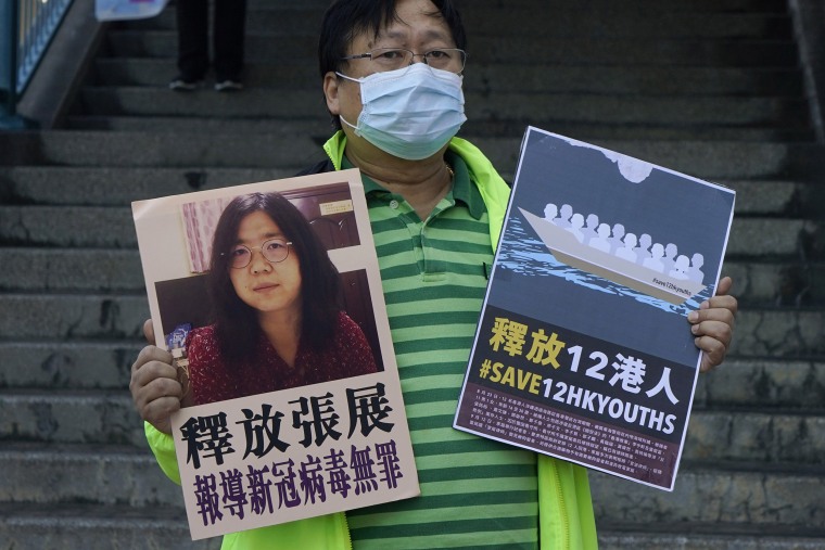 Image: A pro-democracy activist holds placards with the picture of Chinese citizen journalist Zhang Zhan outside the Chinese central government's liaison office, in Hong Kong