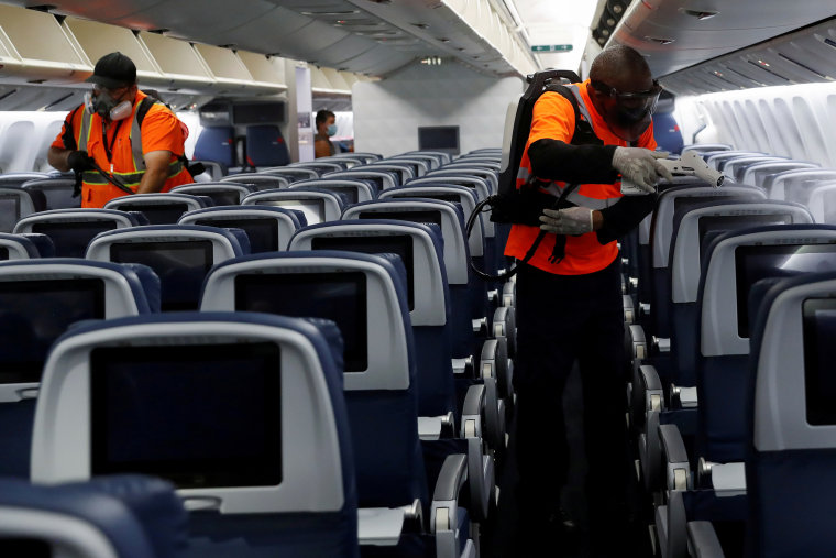 Delta Air Lines pre-flight cleaning crew members use electrostatic disinfection devices to clean an aircraft at JFK International Airport in New York