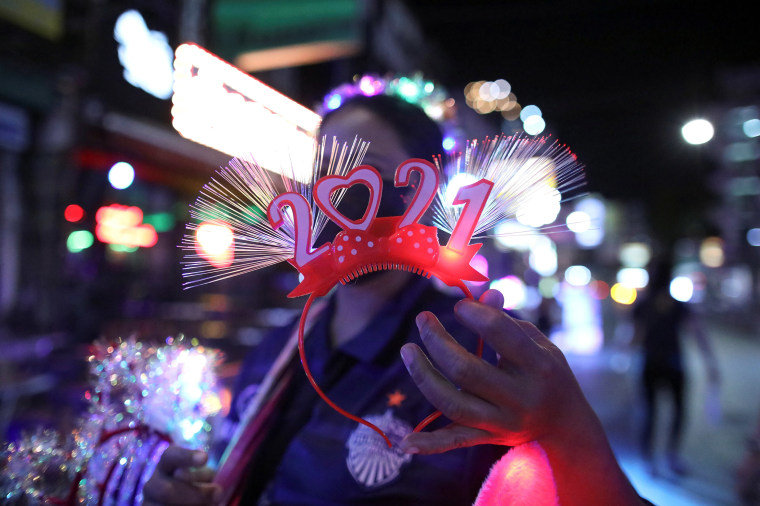 Image: A woman sells a 2021 decoration at a popular entertainment street on New Year's Eve in Bangkok, Thailand