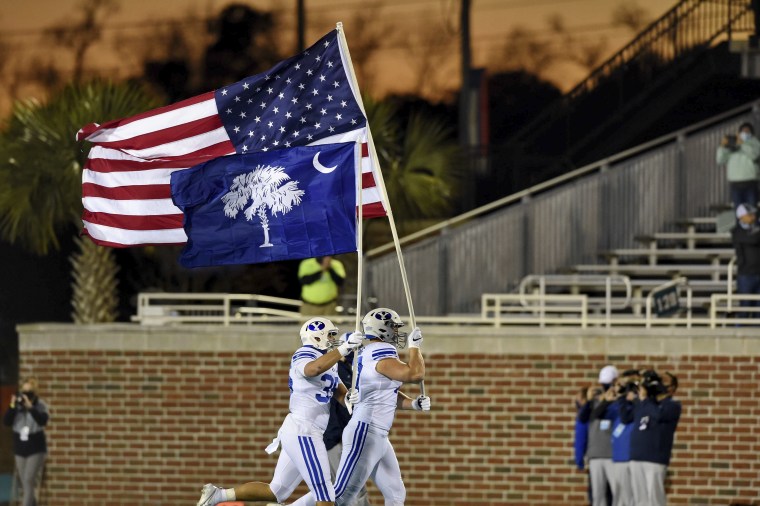 The American and South Carolina flags are carried into Brooks Stadium in Conway, South Carolina before the start of an NCAA college football game between Brigham Young University and Coastal Carolina University Saturday, Dec. 5, 2020.