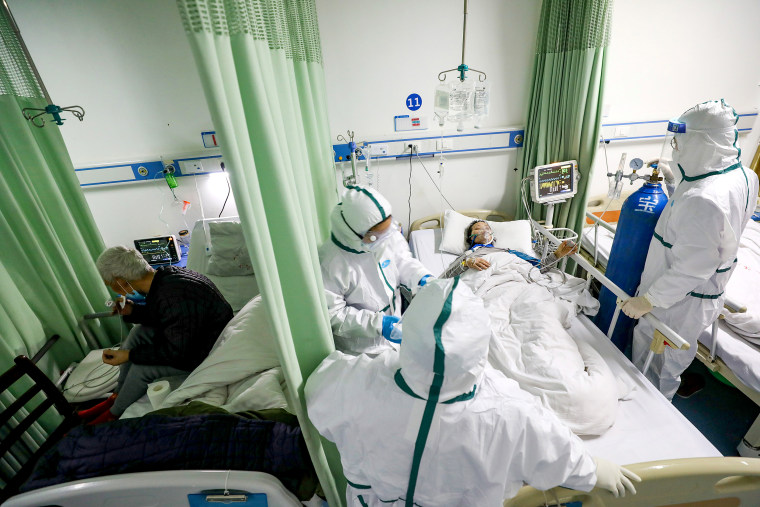 Image: Medical workers in protective suits attend to a novel coronavirus patient at an isolated ward of a designated hospital in Wuhan