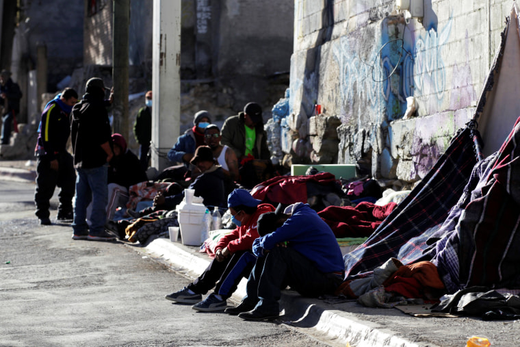 Image: Migrants rest in an improvised shelter set up outside the Posada Belen migrant shelter, which is closed due to an outbreak of the coronavirus disease COVID-19, in Saltillo