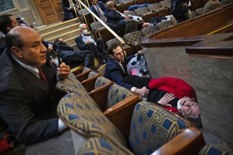 Washington, DC
Rep. Jason Crow, D-Co.,  comforts Rep. Susan Wild, D-Pa., while taking cover as protesters disrupt the joint session of Congress to certify the Electoral College vote on Jan. 6.