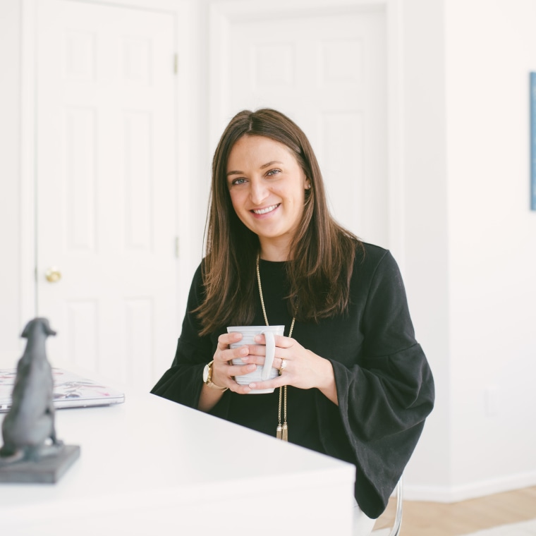 Woman wearing grey sweater holding mug