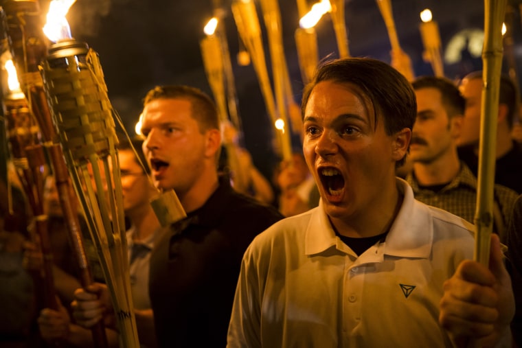 Image: Neo Nazis, Alt-Right, and White Supremacists encircle and chant at counter protesters at the base of a statue of Thomas Jefferson after marching through the University of Virginia campus with torches in Charlottesville, Virginia, Aug. 11, 2017.