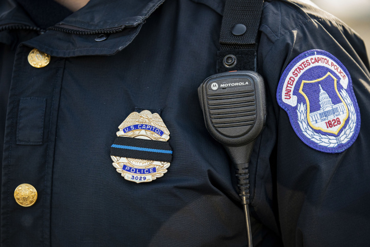 Image: A U.S. Capitol Police officer wears a mourning band over his badge following a police procession of the hearse carrying the casket of Brian Sicknick, U.S. Capitol Police Officer who died from injuries following the U.S. Capitol building siege,