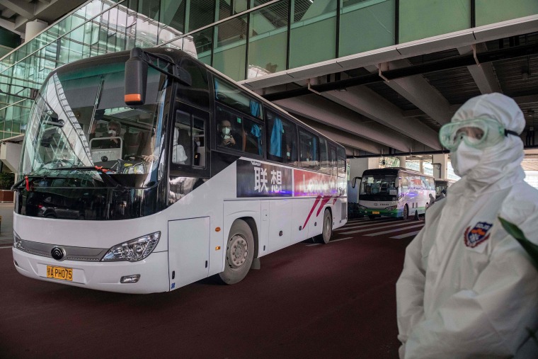 Image: A bus carrying members of the World Health Organization (WHO) team investigating the origins of the Covid-19 pandemic leaves the airport following their arrival at a cordoned-off section in the international arrivals area at the airport in Wuhan