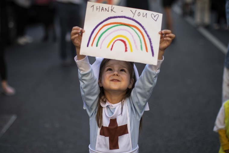 Image: Maria Sole, 4, holds up a homemade sign thanking NHS staff at London's Chelsea &amp; Westminster Hospital.