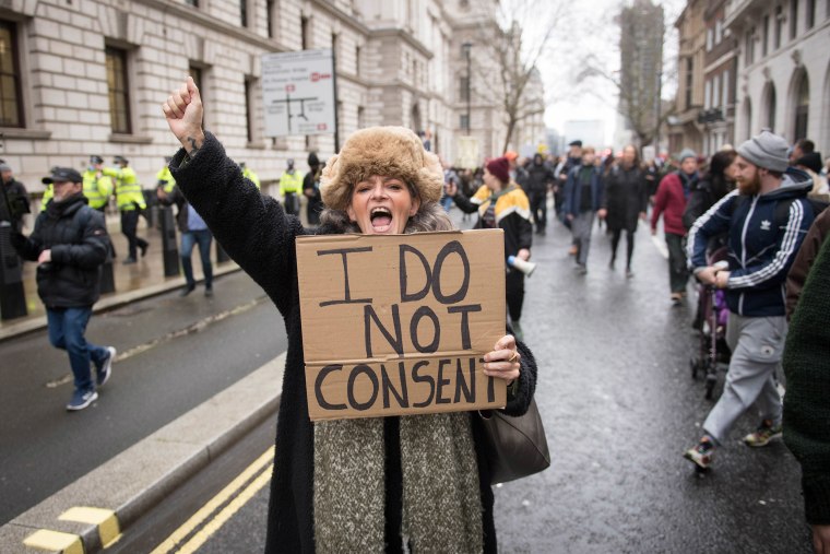 Image: A woman takes part in an anti-vaccination protest in Parliament Square, London.