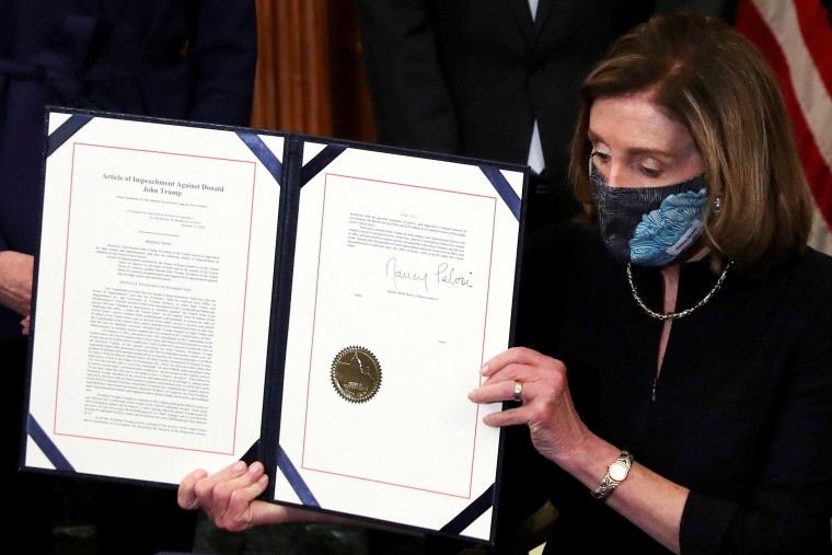 Image: House Speaker Nancy Pelosi shows the article of impeachment against President Donald Trump after signing it in an engrossment ceremony