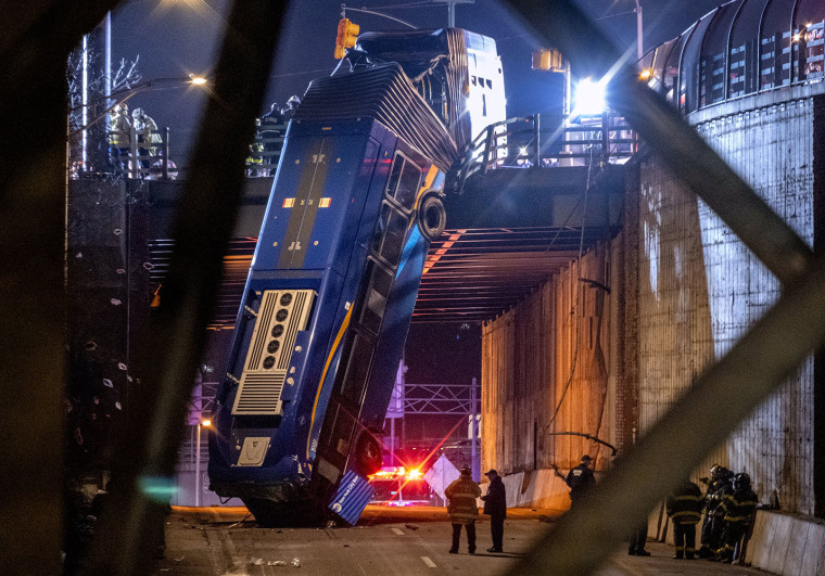 Image: A bus in New York City which careened off a road in the Bronx neighborhood of New York is left dangling from an overpass F