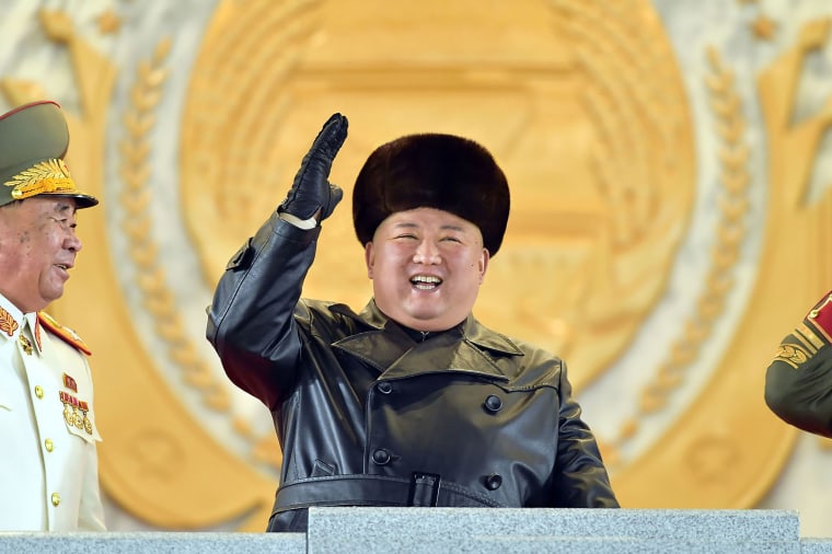 Image: Kim Jong Un, gesturing from the tribune during a military parade, took center stage in Thursday night’s parade.