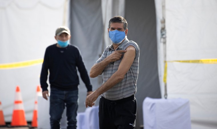 Image: A person gestures while exiting a Disneyland parking lot after receiving a dose of the Moderna COVID-19 vaccine at a mass vaccination site during the outbreak of the coronavirus disease (COVID-19), in Anaheim