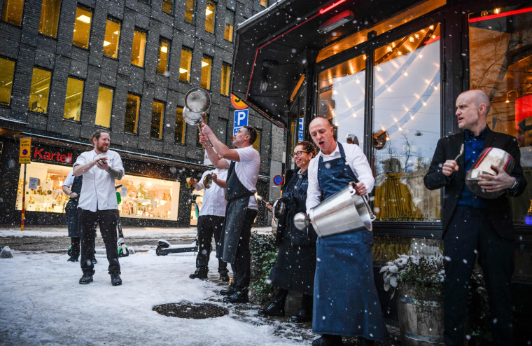 Restaurant owners and their staff make noise to protest against restrictions due to the Covid-19 pandemic, outside a restaurant in central Stockholm, Sweden, on Jan. 14, 2021. Serving alcohol at restaurants after 8 pm is not allowed until January 25, and a maximum of four guests are allowed to sit together.
