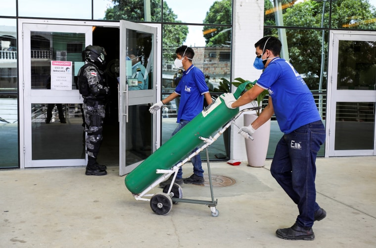Image: A worker arrives with an oxygen cylinder at a hospital in Manaus, Brazil