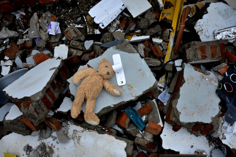 Image: A teddy bear lies among the ruins of a collapsed building following an earthquake in Mamuju