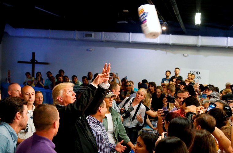 Image: President Trump throws a roll of paper towels to residents gathered in a chapel while visiting areas damaged by Hurricane Maria in San Juan, Puerto Rico