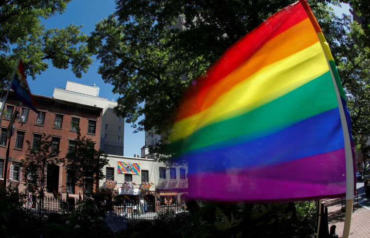 A rainbow flag waves in the wind at the Stonewall National Monument outside the Stonewall Inn in New York