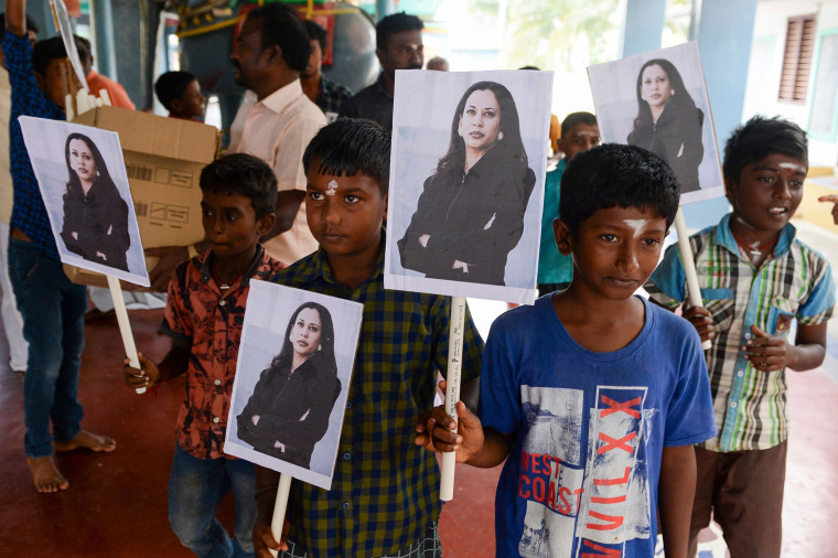 Image: Villagers pose holding photos of US Vice President-elect Kamala Harris at her ancestral village of Thulasendrapuram in the southern Indian state of Tamil Nadu