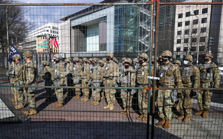 Image: Military personnel standby along Pennsylvania Avenue as President-elect Joe Biden's motorcade arrives at the U.S. Capitol, in Washington