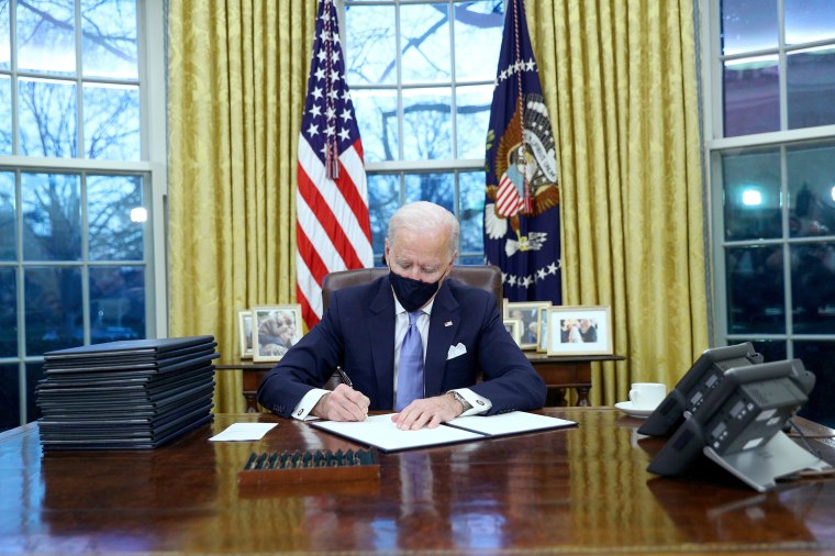 Image: President Joe Biden signs executive orders in the Oval Office of the White House in Washington, after his inauguration as the 46th President of the United States