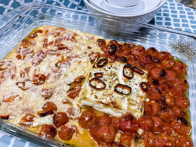 Once the baked feta is removed from the oven, it's time to mix the tomatoes and cheese together.