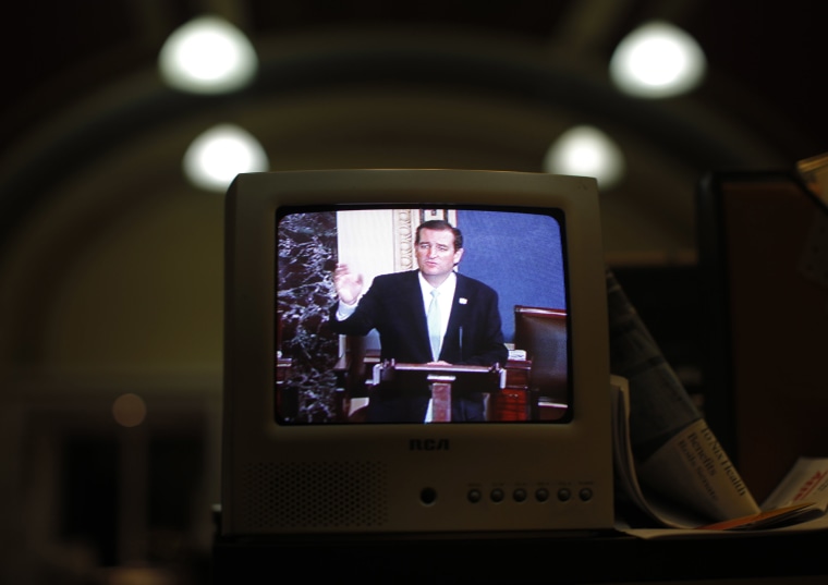 Image: Seen on a television screen in the Senate Press Gallery, Sen. Ted Cruz, R-Texas, speaks during the seventh hour of his filibuster on the Senate floor