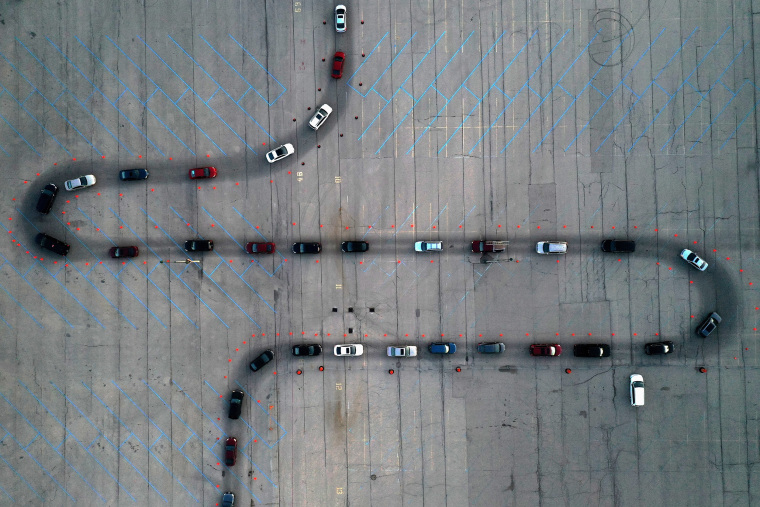 Image: An aerial view of vehicles waiting at a drive-thru Covid-19 testing site in the parking lot of Miller Park in Milwaukee, Wisconsin.