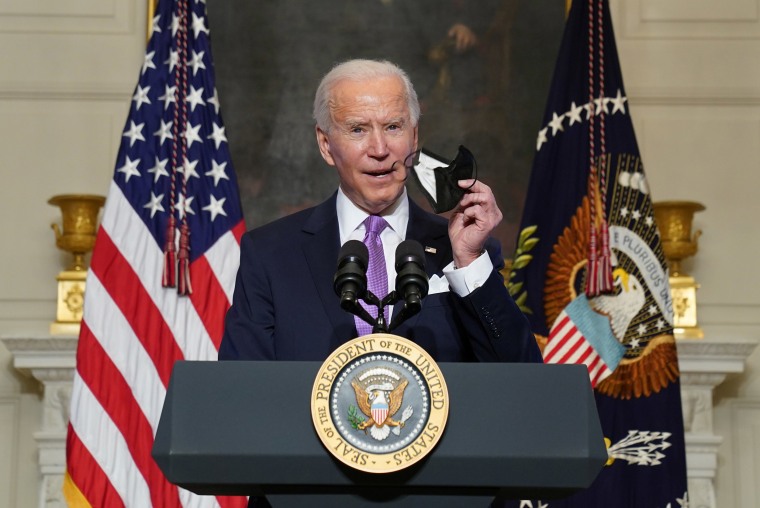 Image:President Joe Biden holds up a face mask as he speaks about the fight to contain the Covid-19 pandemic, at the White House.