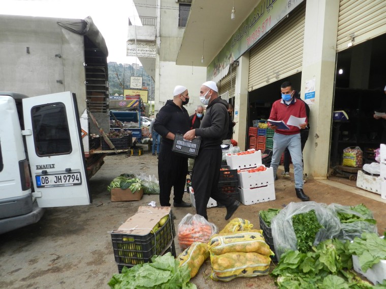 Image: Workers prepare fruit and vegetables to be delivered to local residents in Nabatieh, southern Lebanon.