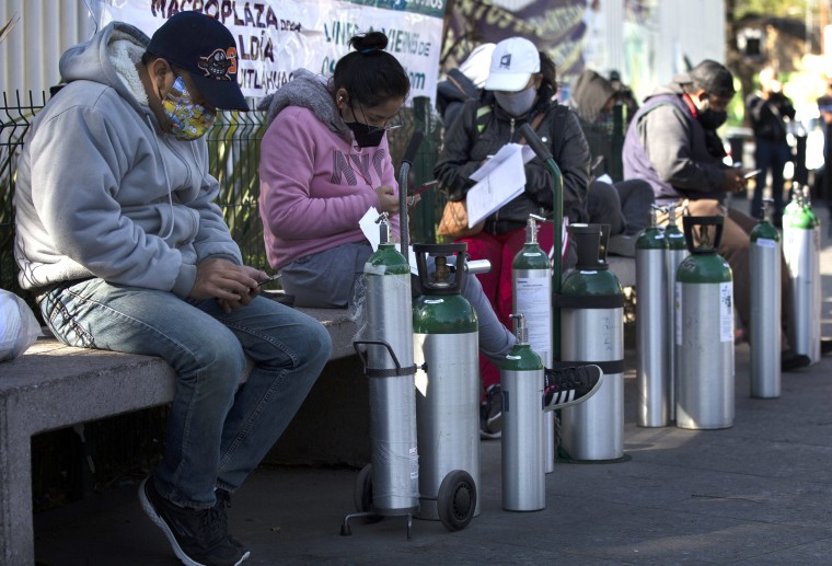 Image: People wait to refill oxygen tanks for relatives sick with COVID-19 in the Iztapalapa district of Mexico City