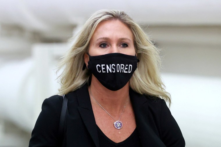 Image: Representative Marjorie Taylor Greene (R-GA) wears a mask reading \"Censored\" as she walks to the House floor during debate on the second impeachment of President Donald Trump.
